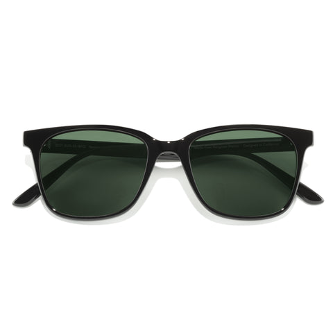 Black sunglasses with green lenses on a white background