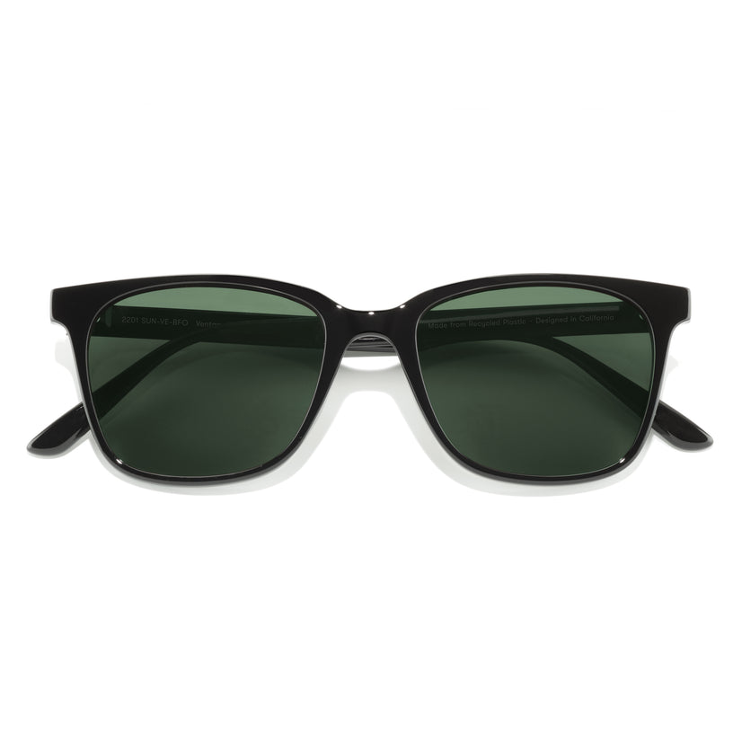 Black sunglasses with green lenses on a white background