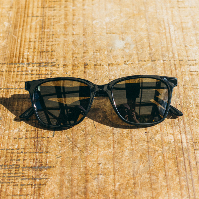 Black sunglasses on a wooden surface