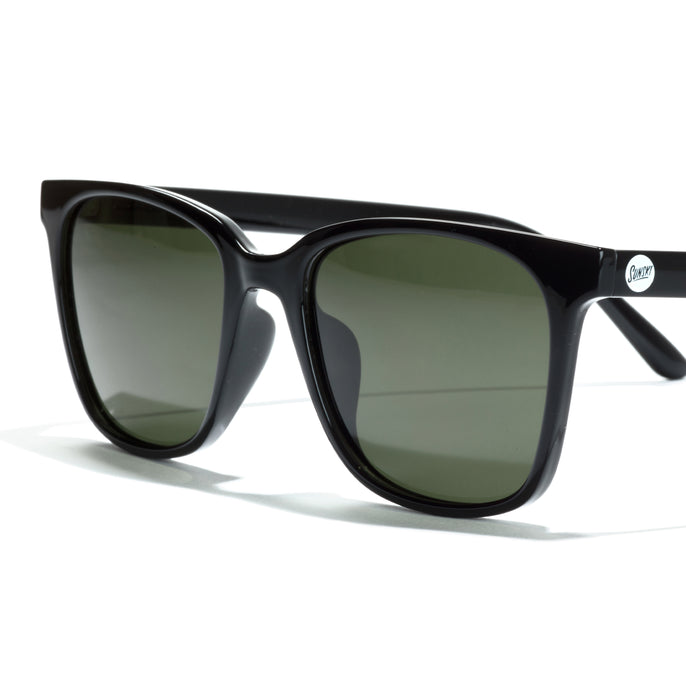 Black sunglasses with green lenses on a white background
