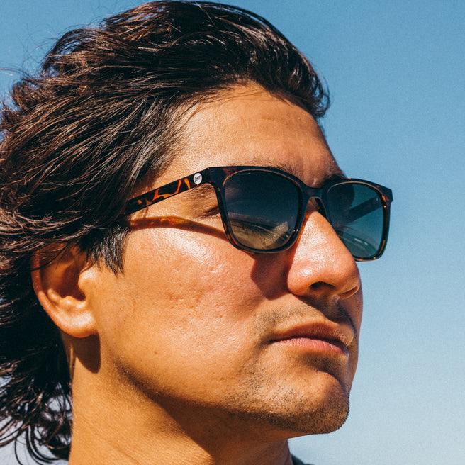 Man wearing sunglasses with a clear blue sky background