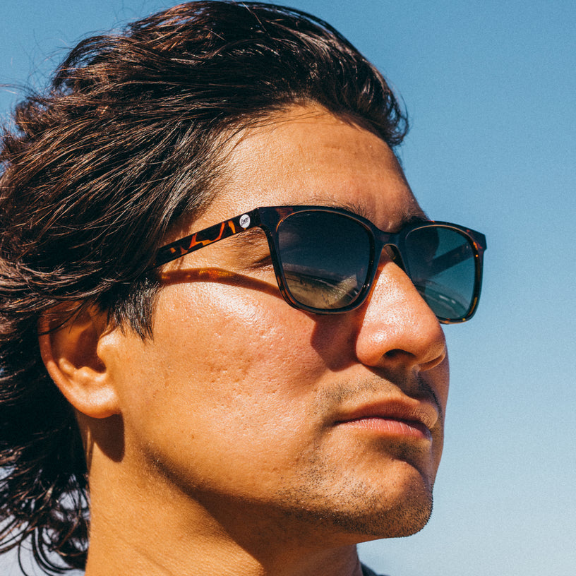 Man wearing sunglasses with a clear blue sky background