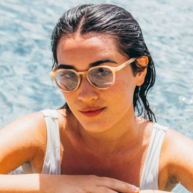 Woman wearing sunglasses with a blurred water background
