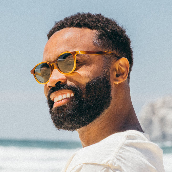 Man wearing sunglasses with a beach background