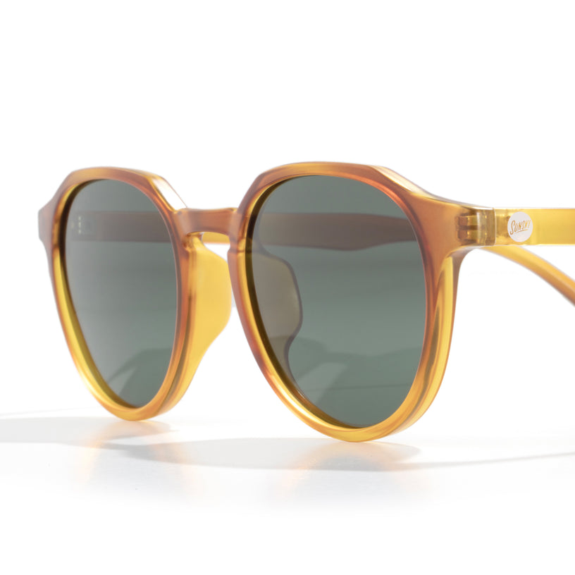 Round sunglasses with yellow frame and dark lenses on a white background