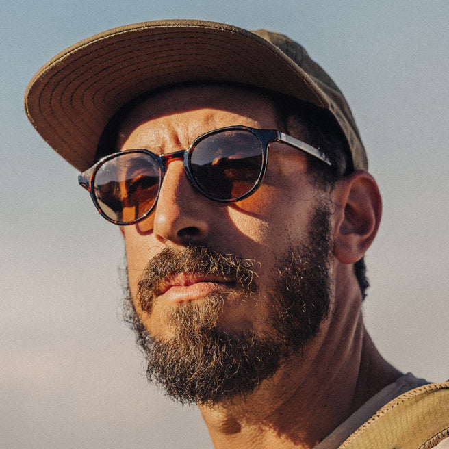 Man wearing sunglasses and a cap with a blurred background