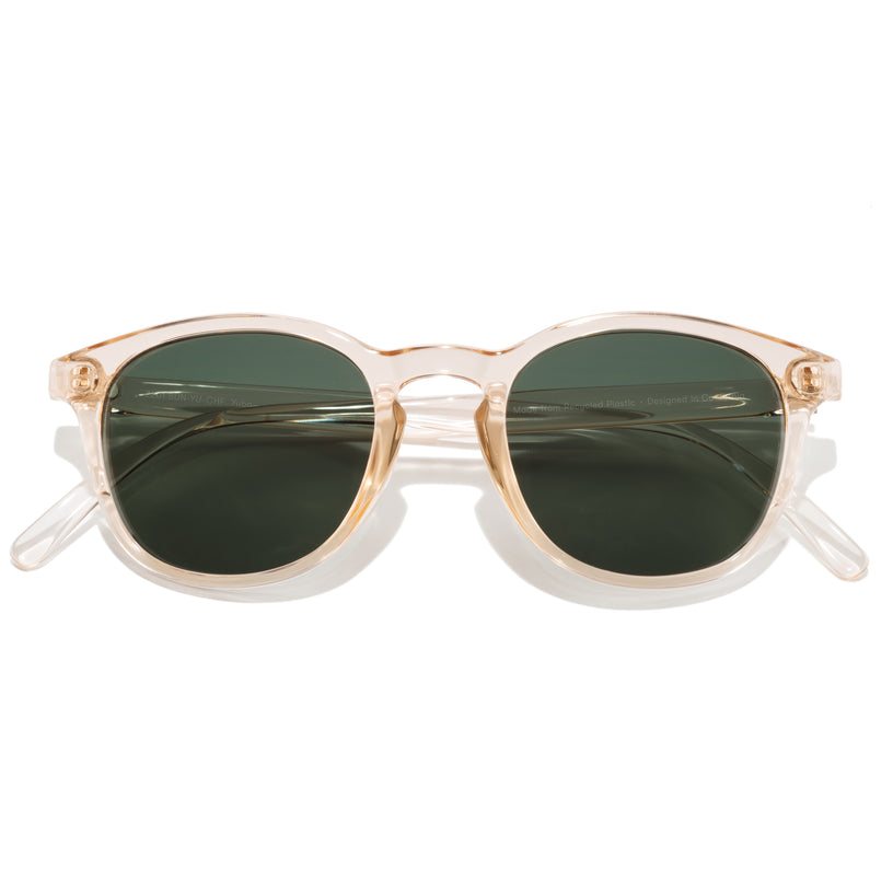 Sunglasses with gold frame and green lenses on a white background