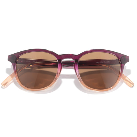 Sunglasses with purple frame and brown lenses on a white background