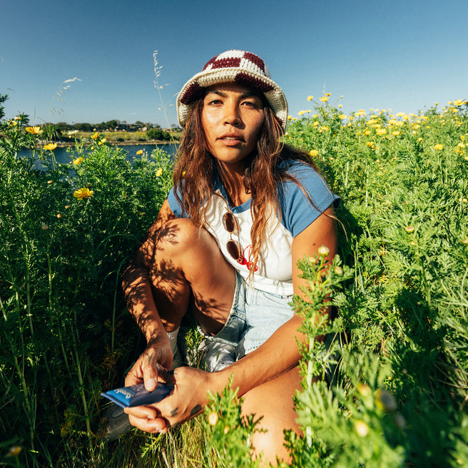 Woman in a field of flowers holding a phone