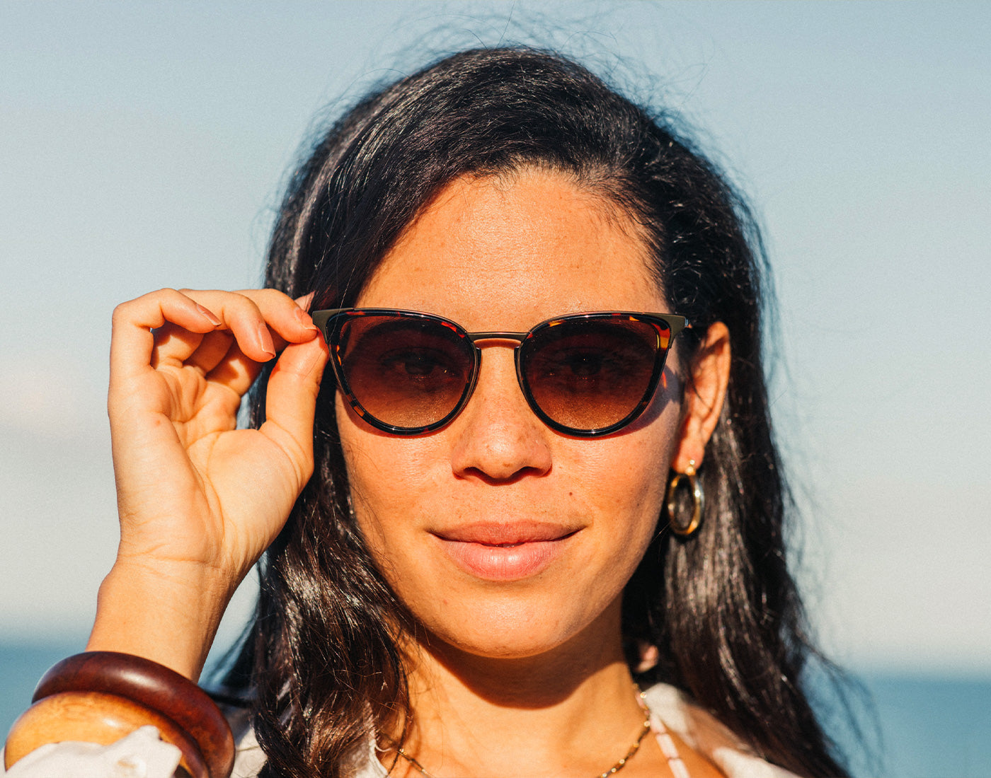 girl holding sunski catalina sunglasses on face