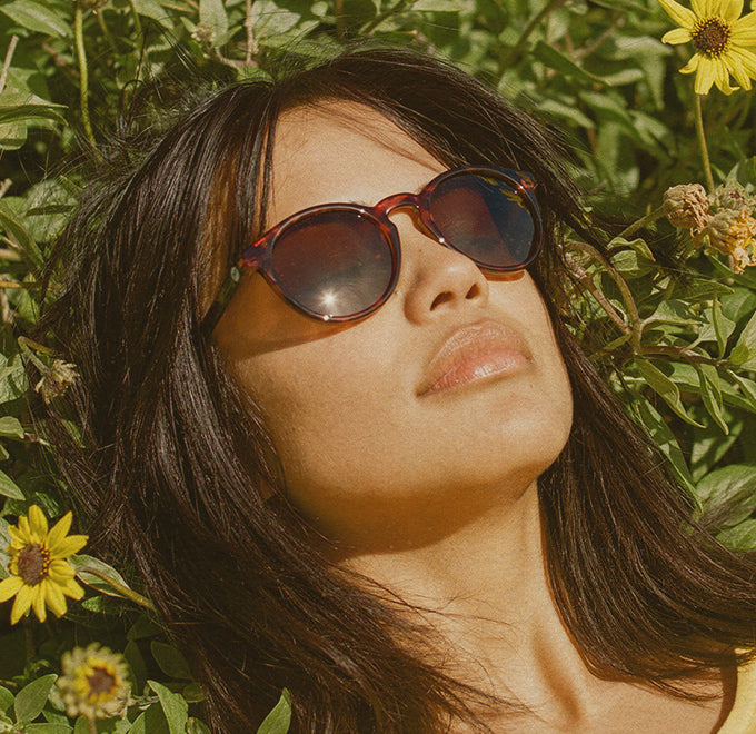 woman in flowers wearing sunski sunglasses