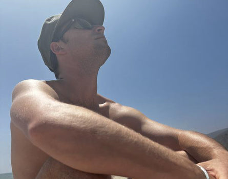 Man sitting on a beach with a clear blue sky