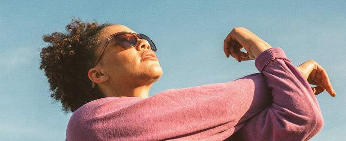 woman stretching wearing sunski anza sunglasses