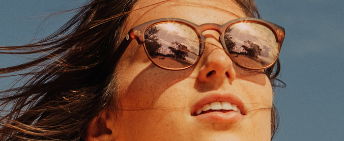 close up of woman wearing sunski avila sunglasses looking up to the sun