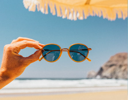baia tangerine midnight held in a woman's hand with the beach in the background