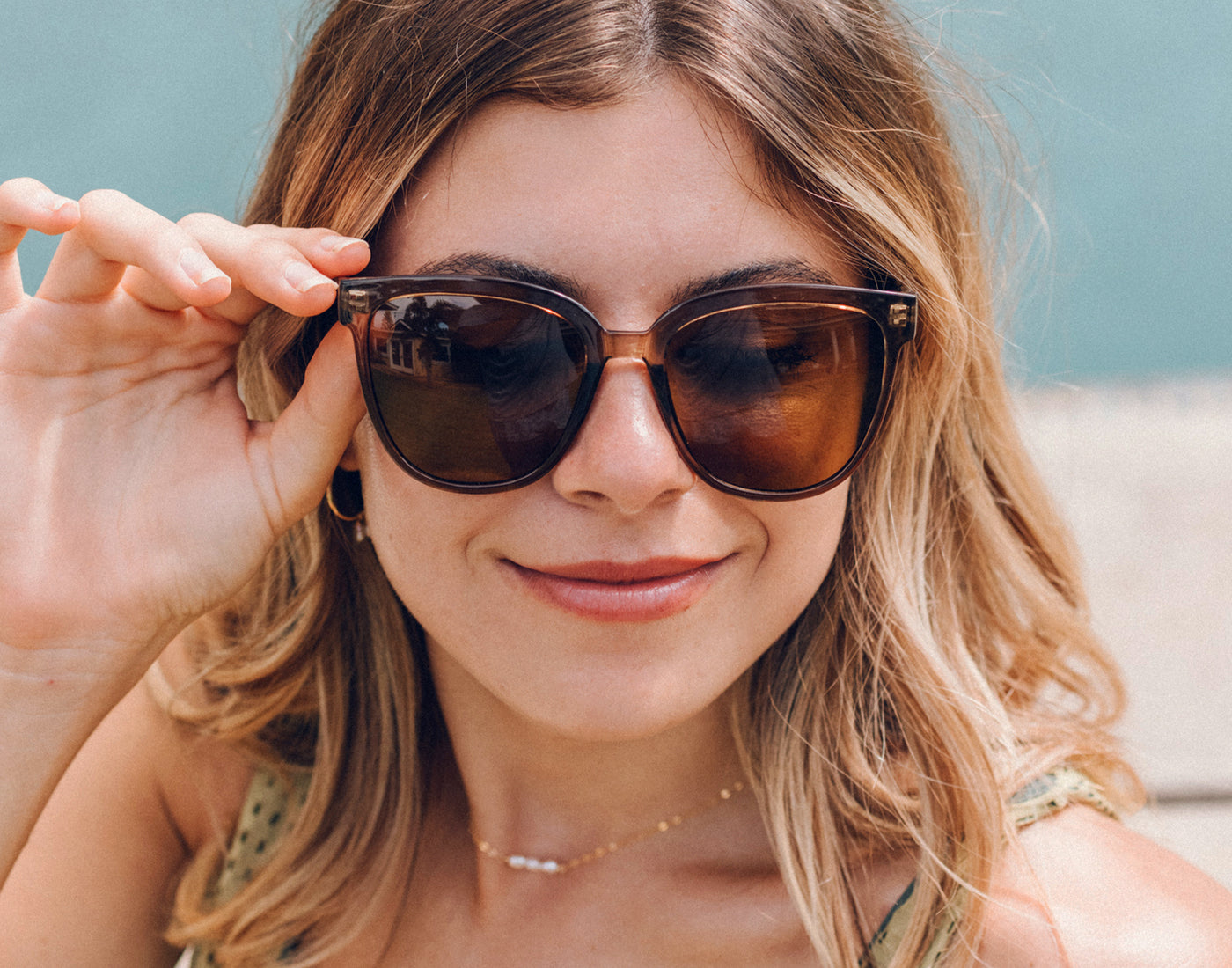 sunski camina cola amber girl holding sunglasses on face