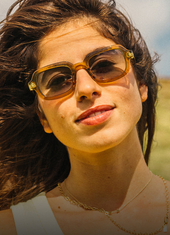 Woman wearing sunglasses with a blurred natural background