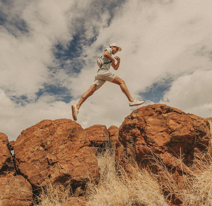 guy jumping from rock to rock wearing sunski sling