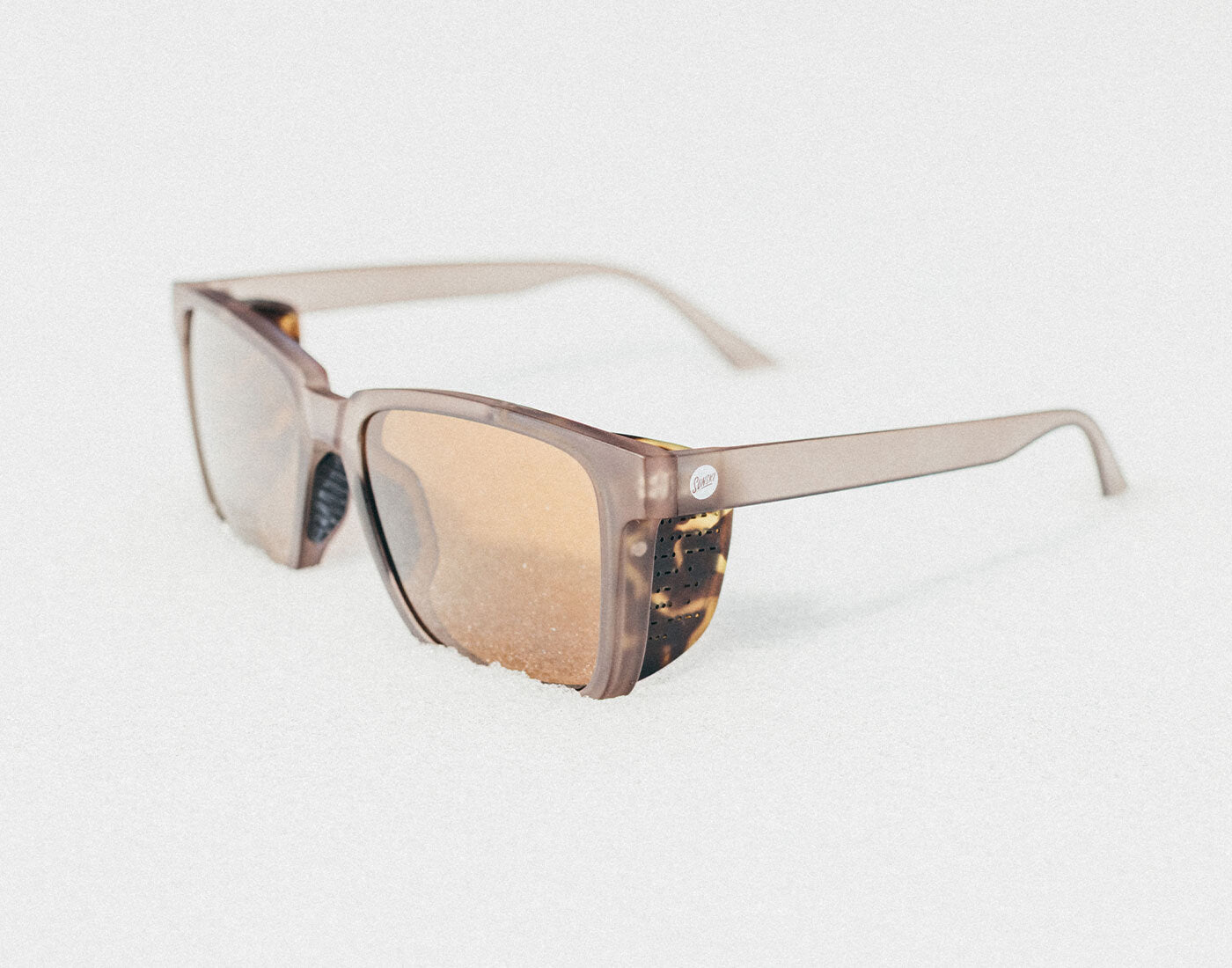Sunglasses with a tortoiseshell frame on a light gray background