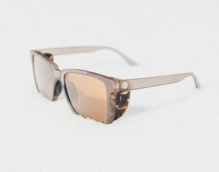 Sunglasses with a tortoiseshell frame on a light gray background
