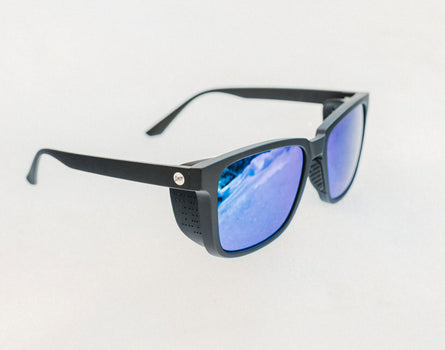 Black sunglasses with blue lenses on a light gray background