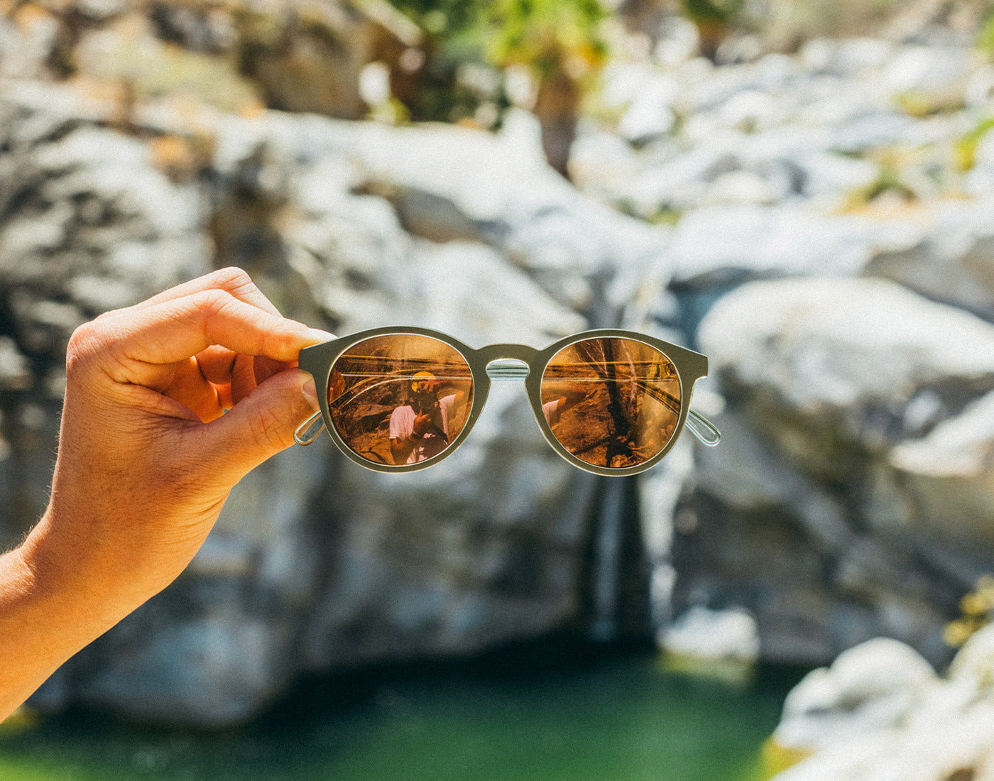 dipsea sunglasses in front of waterfall