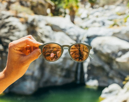dipsea sunglasses in front of waterfall