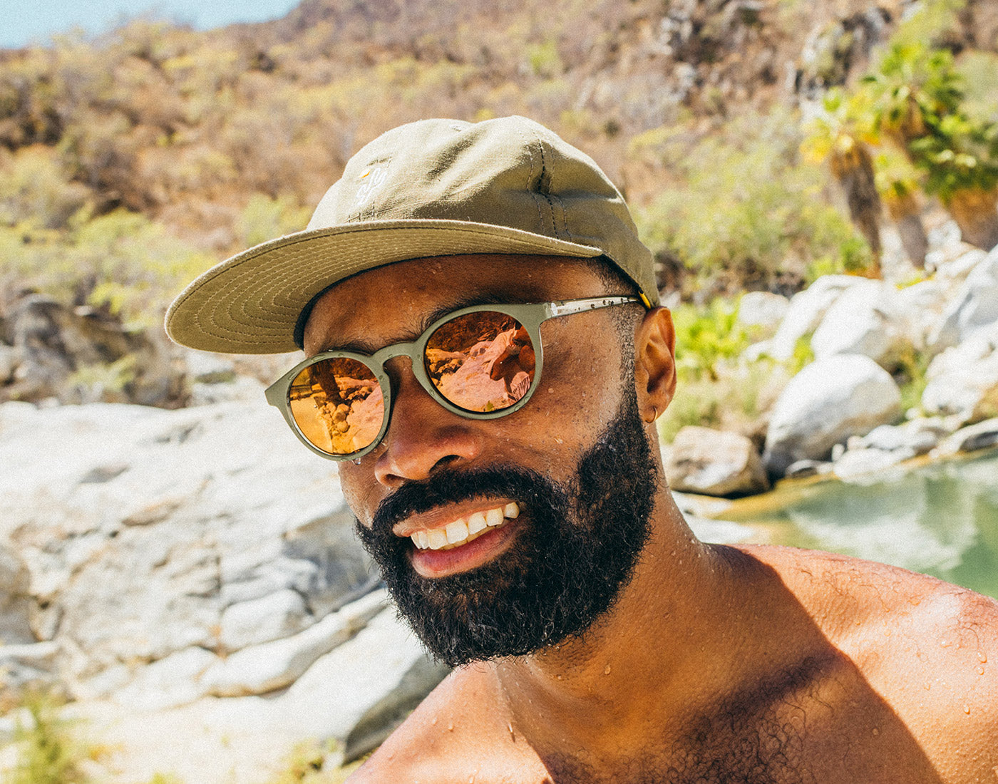 man wearing dipsea sunglasses at and hat at waterfall