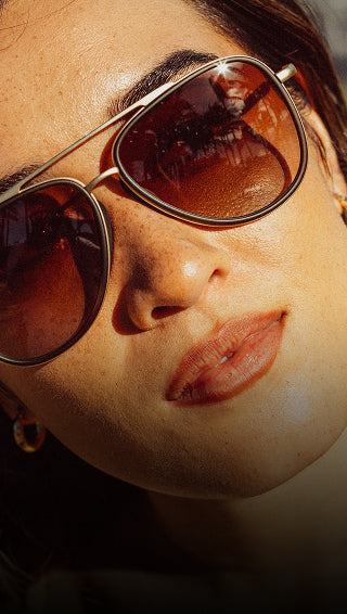 Close-up of a person wearing sunglasses with a blurred background