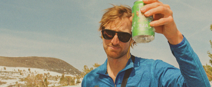 man cheering drink wearing sunski polarized mountaineering sunglasses