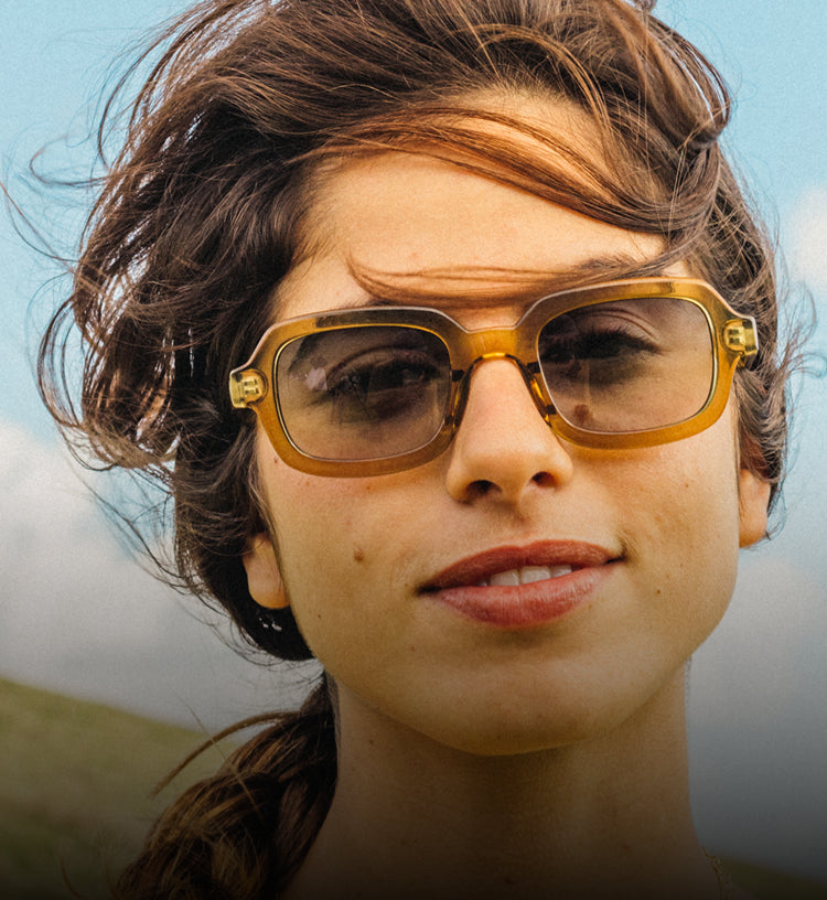 Person wearing yellow sunglasses with a blurred background
