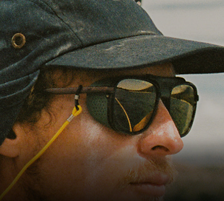 Person wearing a cap and sunglasses with a blurred background