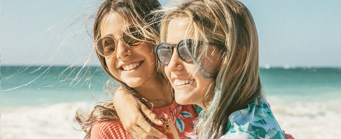 two girls hugging wearing sunski kids' polarized sunglasses