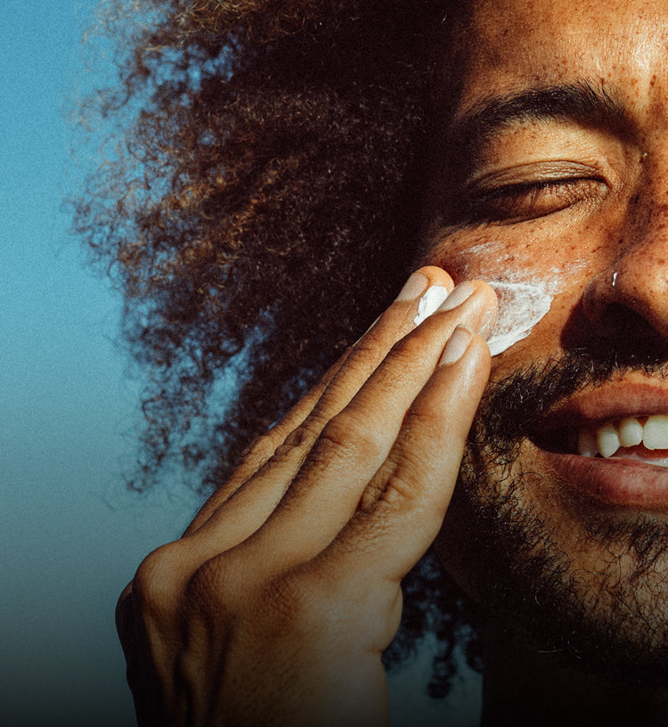Person applying cream to their face with a blurred background