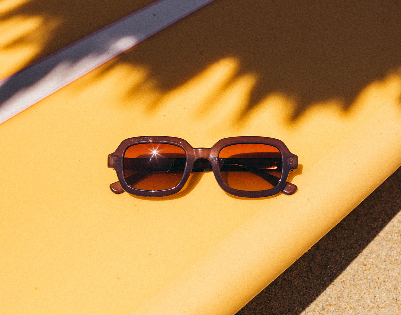 lago fog smoke tera fade sunglasses on surfboard