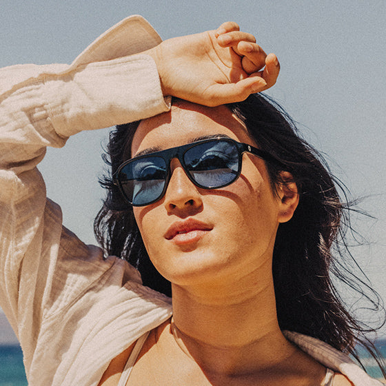 woman with hand on head wearing sunski tinted sunglasses