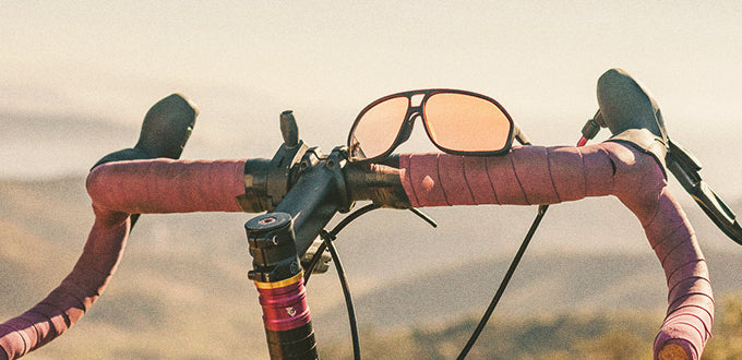 sunski velo sunglasses sitting on bike handles