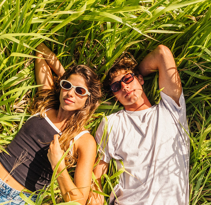 man and woman in wild eyes sunglasses in a field