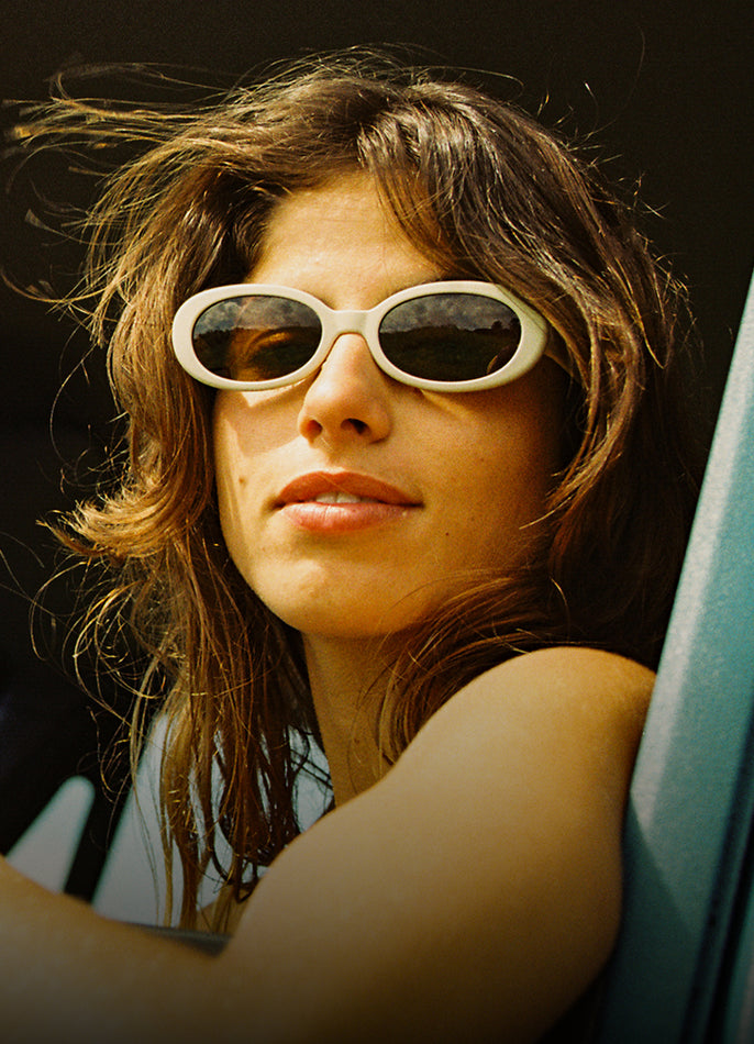 Woman wearing white sunglasses with a blurred background