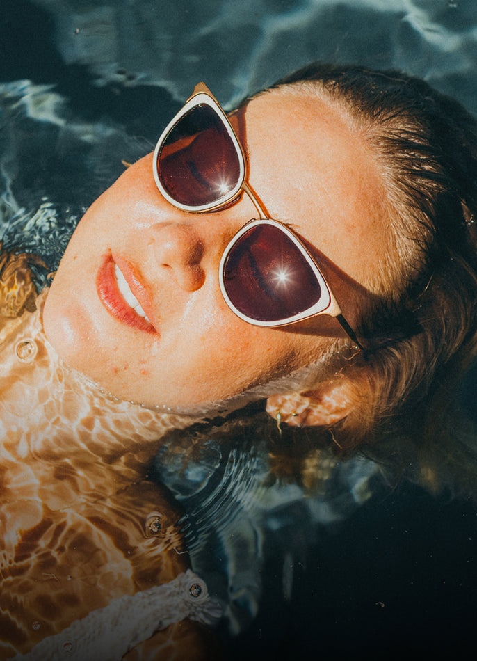 Person wearing sunglasses floating in water