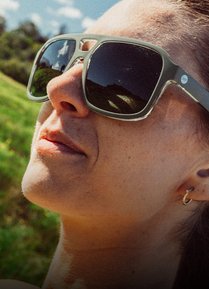 Person wearing sunglasses with a blurred natural background