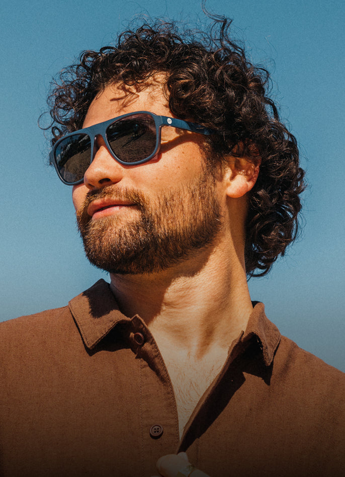 Man wearing sunglasses with a clear blue sky background
