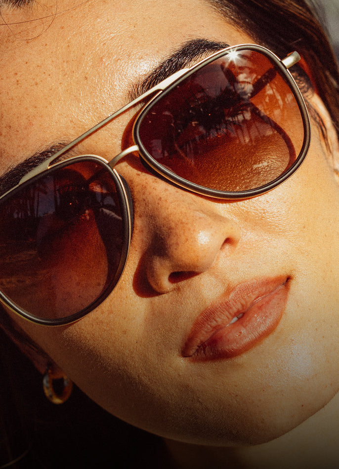 Close-up of a person wearing sunglasses with a warm filter