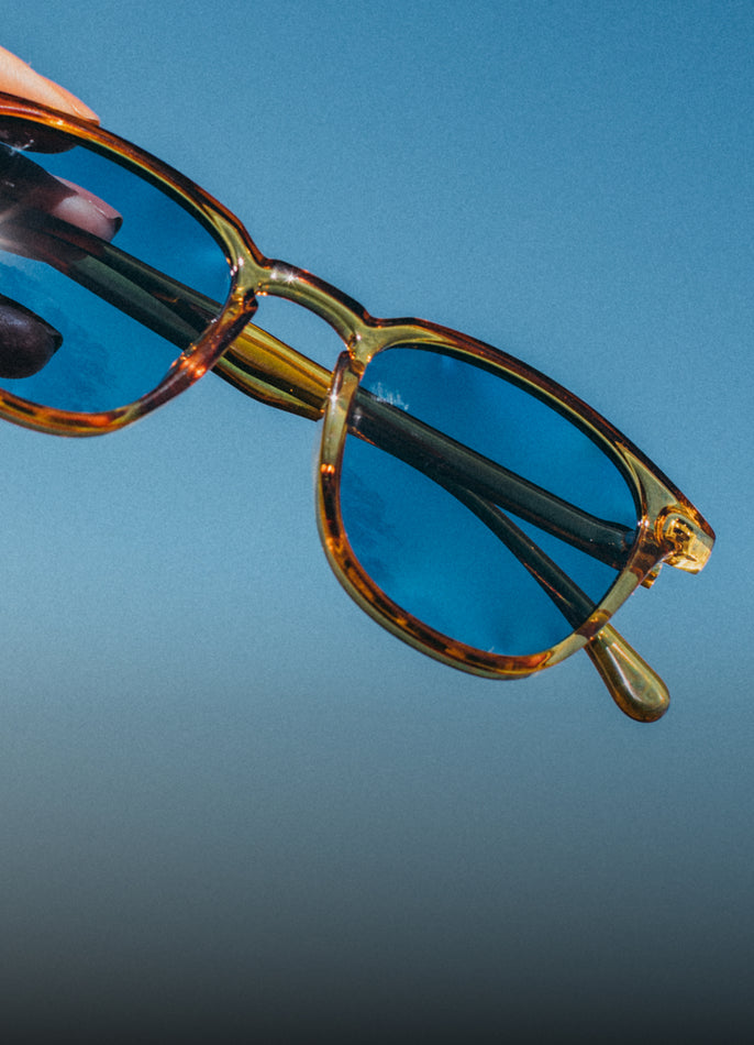 Sunglasses with a reflective surface against a blue sky