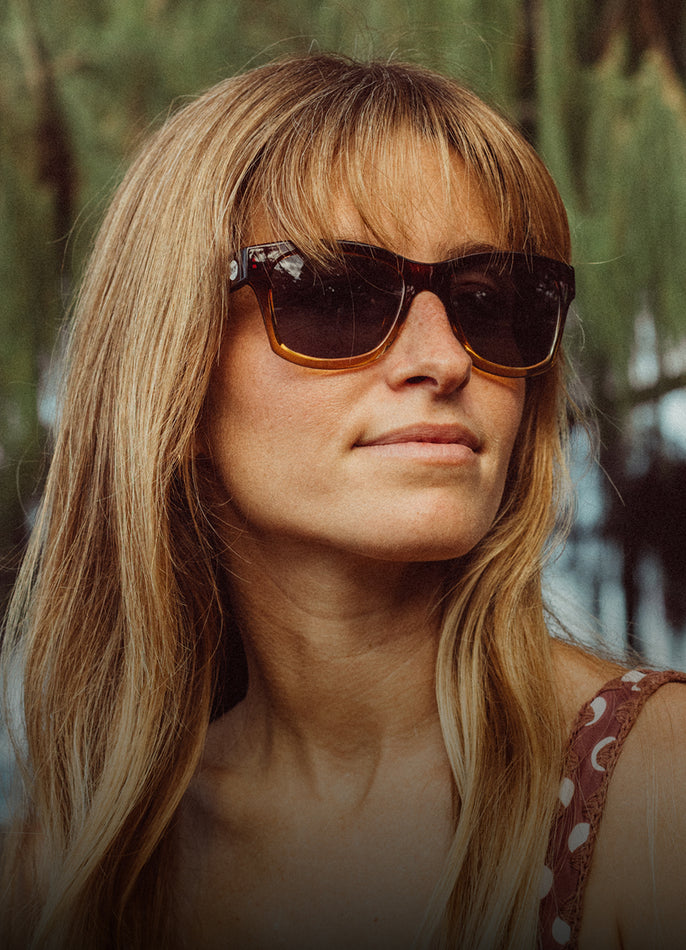 Woman wearing sunglasses with a blurred natural background