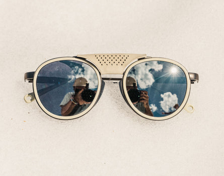 Round sunglasses with reflective lenses on a light background