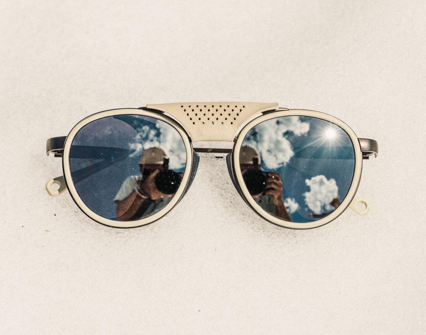Round sunglasses with reflective lenses on a light background