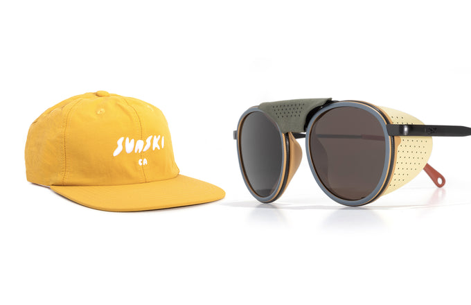 Yellow cap with 'Sunski' logo and round sunglasses on a white back