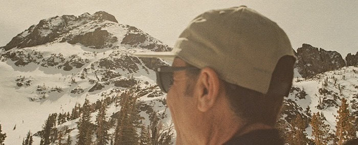 man in the mountains wearing a sunski hat
