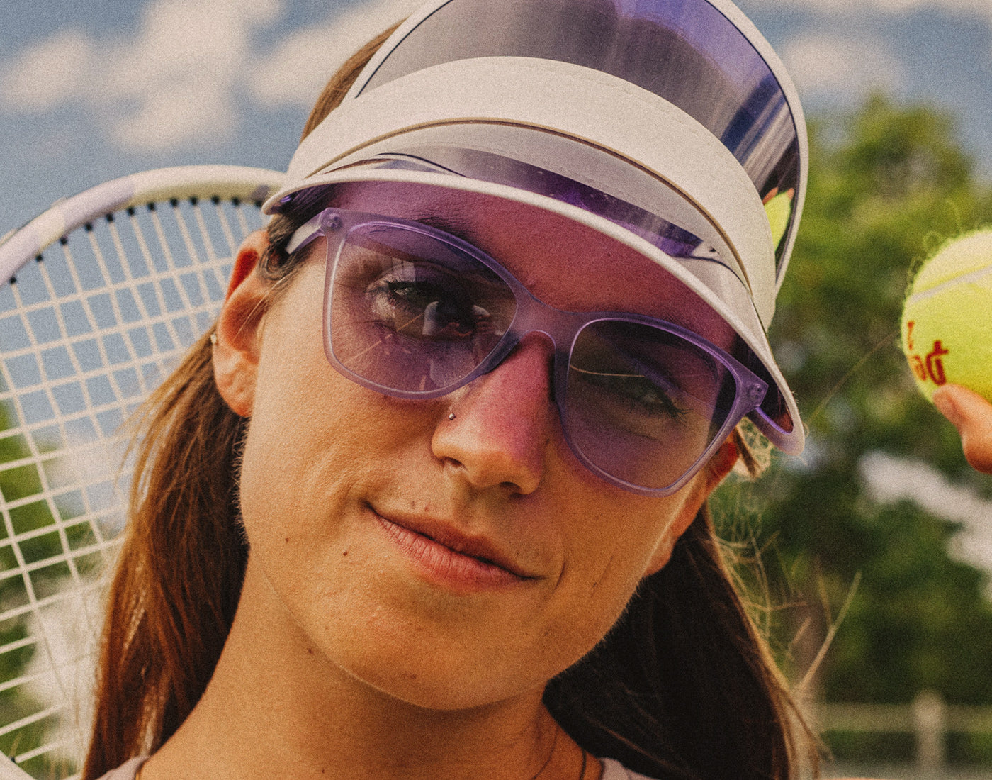 woman wearing matching visor and sunski anza sunglasses